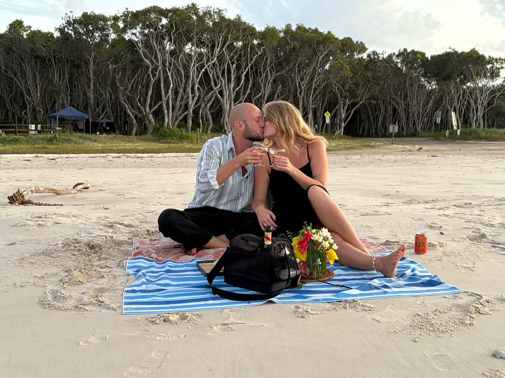Natalie and Calvin sharing a kiss on the beach